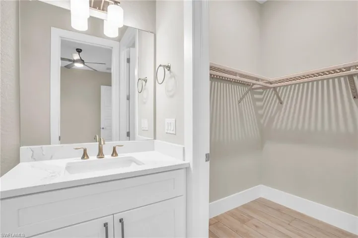 Bathroom with vanity, ceiling fan, and hardwood / wood-style floors