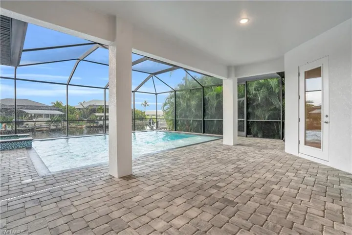 View of pool with a patio, a lanai, and a water view