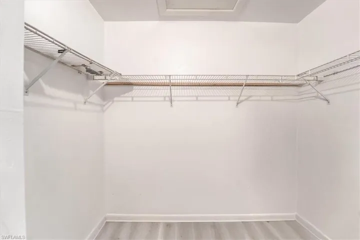 Walk in closet with wood-type flooring
