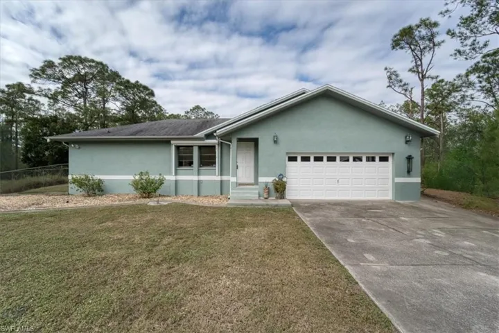 Single story home featuring a front yard and a garage