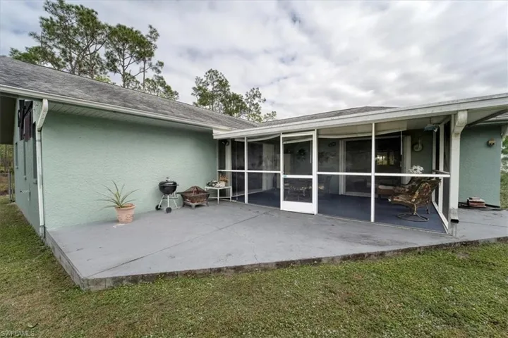 Back of house with a patio area, a sunroom, and a yard
