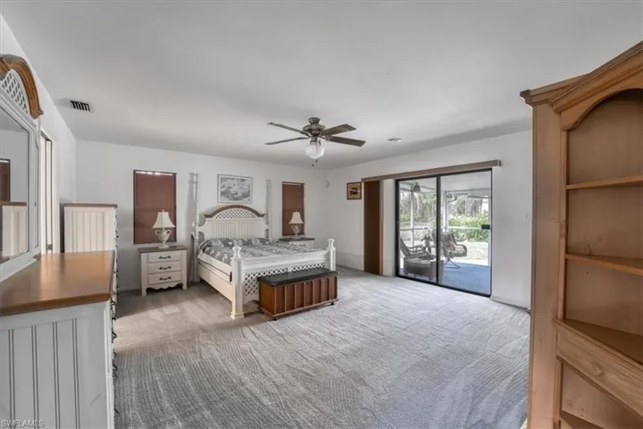 Bedroom with access to exterior, light carpet, and ceiling fan