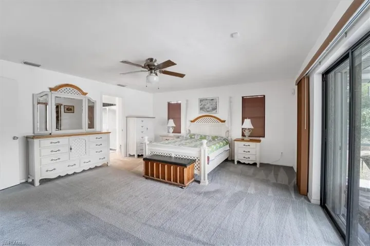 Carpeted bedroom featuring ceiling fan