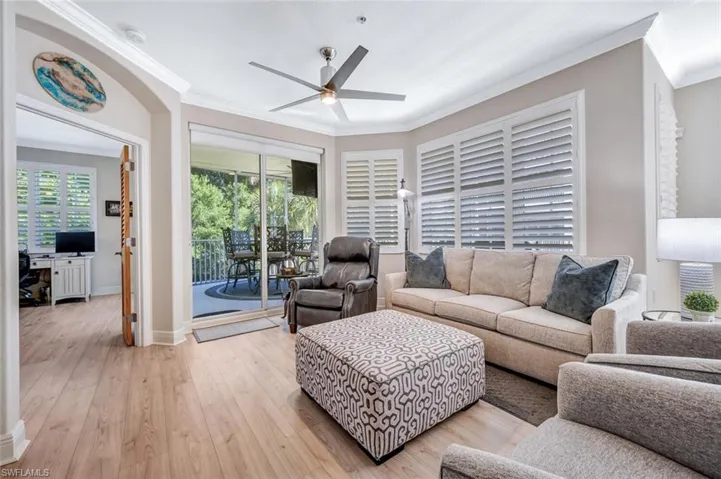 Living room with crown molding, ceiling fan, and light hardwood / wood-style flooring