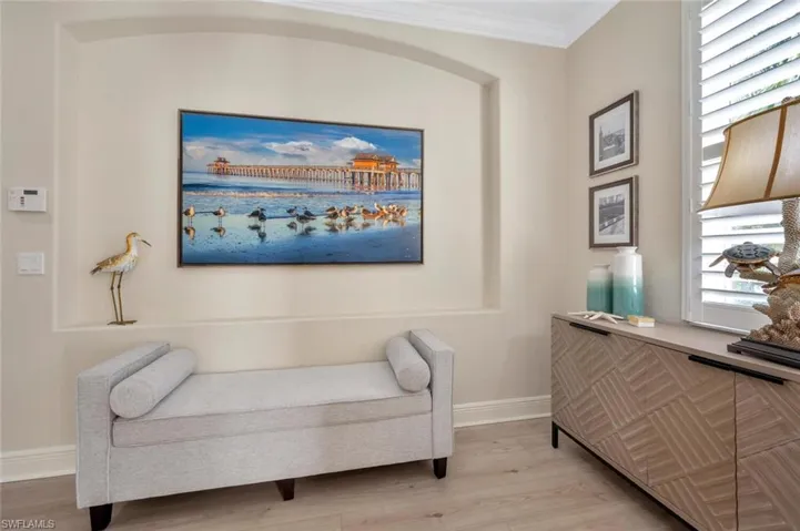 Living area with hardwood / wood-style flooring and crown molding