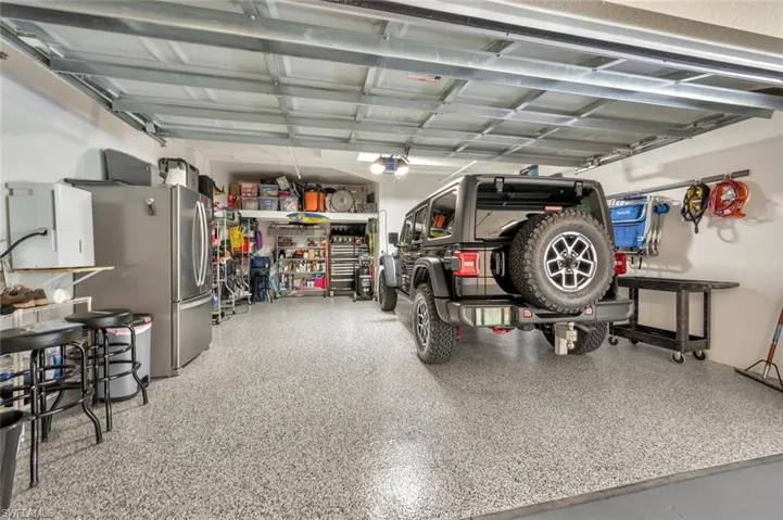 Garage featuring a workshop area and stainless steel fridge