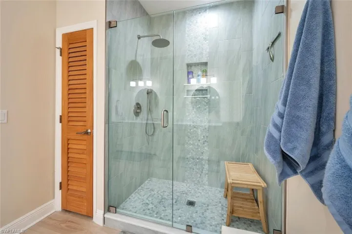 Bathroom with an enclosed shower and hardwood / wood-style floors