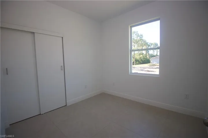 Bedroom featuring light tile patterned flooring and a closet