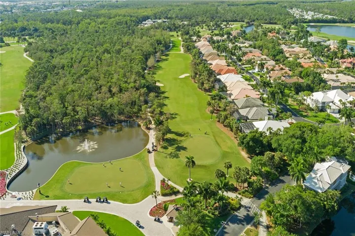 Aerial view of property and surrounding area with a nearby body of water and a golf course
