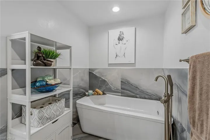 Full bathroom featuring a tub and tile walls