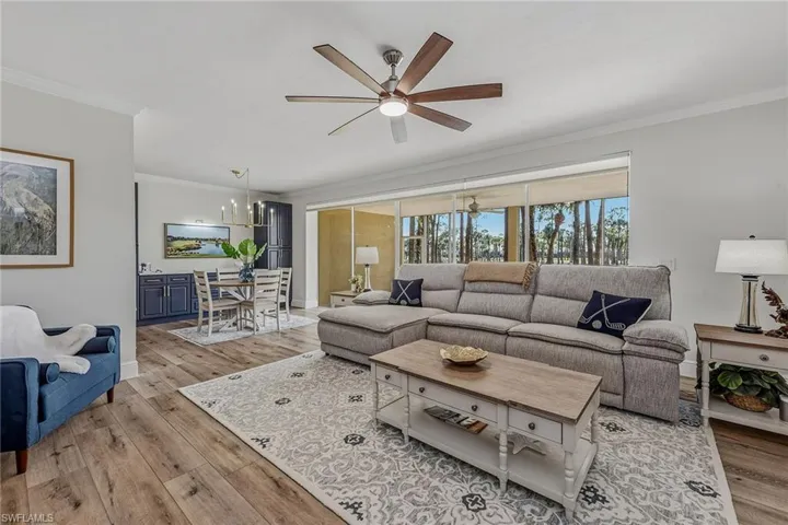 Living area with ornamental molding, a ceiling fan, and light wood finished floors