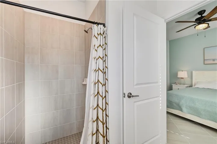 Full bathroom featuring a tiled shower stall, tile patterned flooring
