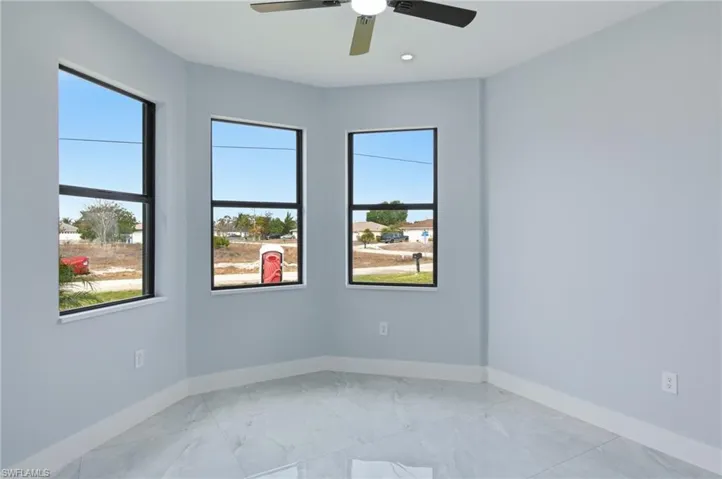 Spare room featuring a ceiling fan and light marble finish flooring