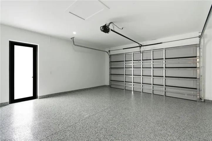 Garage with a garage door opener and baseboards