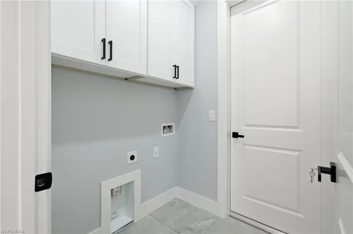 Laundry room featuring cabinet space, hookup for an electric dryer, hookup for a washing machine, and light marble finish floors