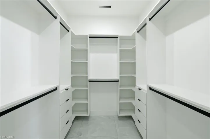 Walk in closet with light marble finish floors