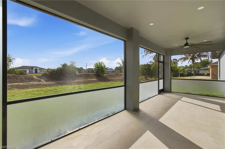 Unfurnished sunroom featuring a ceiling fan