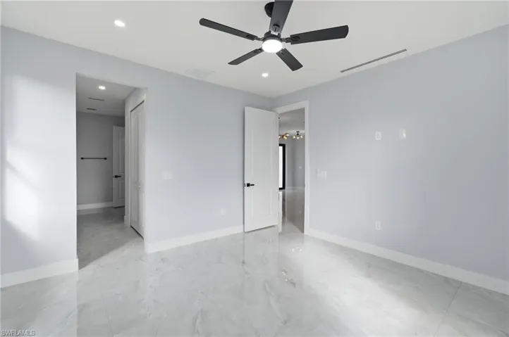 Unfurnished bedroom with ceiling fan, recessed lighting, and light marble finish flooring