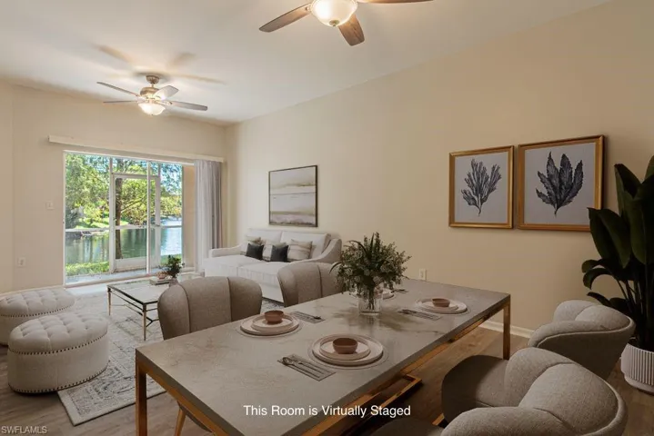 Dining space featuring wood finished floors, a water view, and ceiling fan