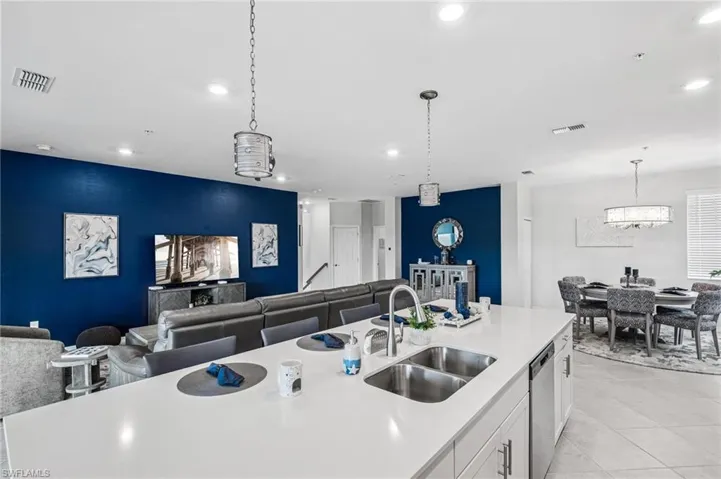 Kitchen featuring stainless steel dishwasher, light countertops, white cabinetry, pendant lighting, and recessed lighting