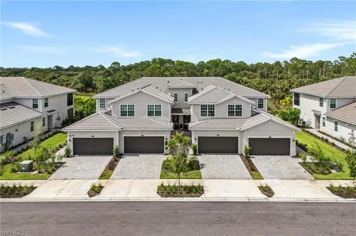 View of front of home featuring a tiled roof, decorative driveway, and a garage