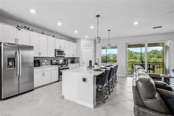 Kitchen featuring appliances with stainless steel finishes, open floor plan, recessed lighting, backsplash, and light countertops
