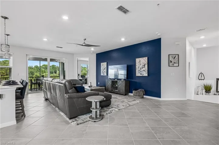 Living room featuring recessed lighting, an accent wall, a ceiling fan, and light tile patterned floors