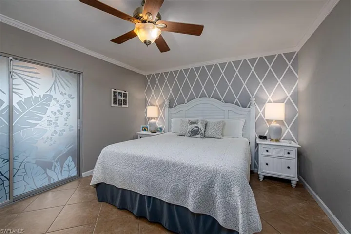 Bedroom featuring tile patterned flooring, ceiling fan, and ornamental molding