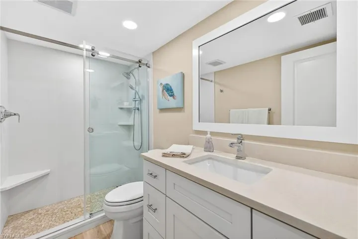 Bathroom with vanity, a stall shower, and recessed lighting