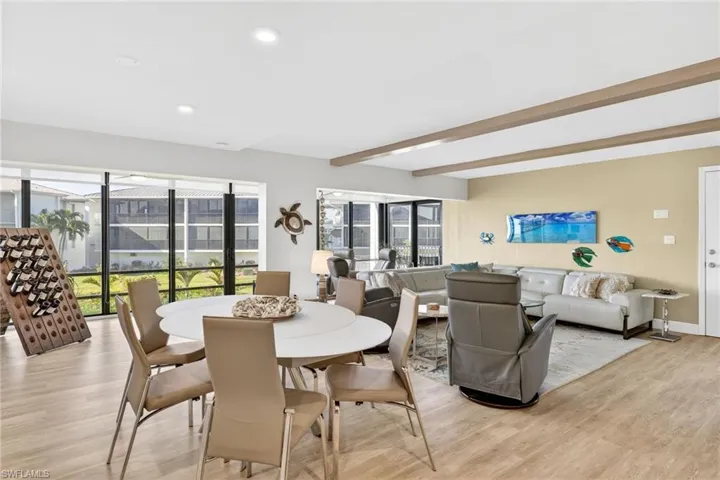 Dining space featuring light wood-style flooring and beamed ceiling