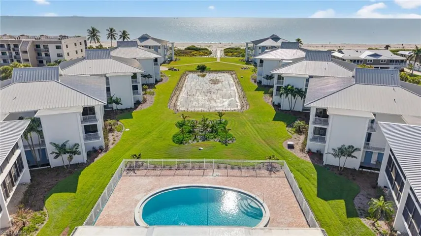 Aerial perspective of suburban area with a pool and a large body of water