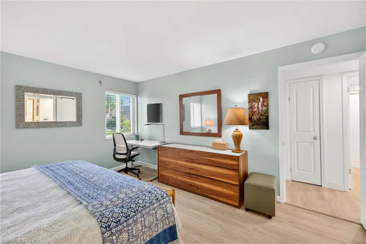 Bedroom with light wood-style flooring and an office area