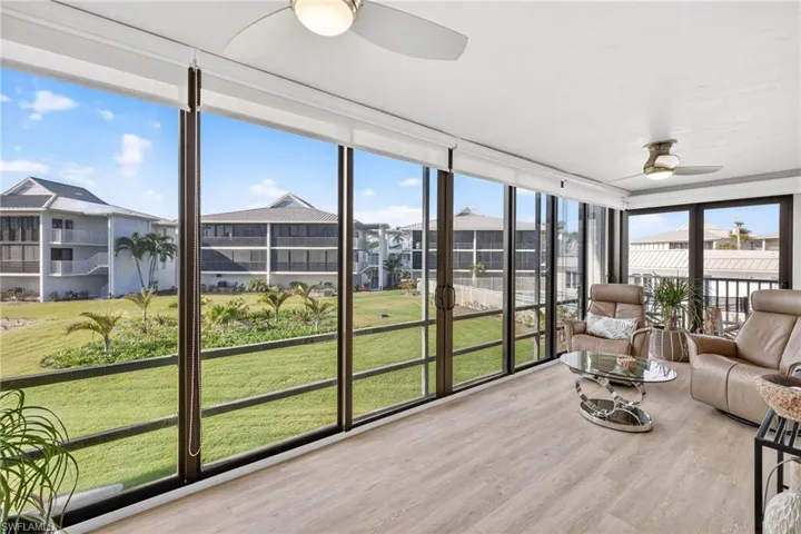 Sunroom / solarium with expansive windows and wood finished floors