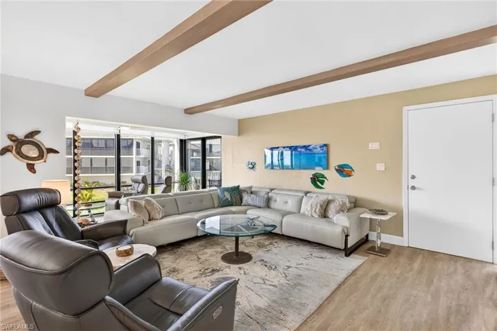Living area featuring beamed ceiling and light wood-style flooring