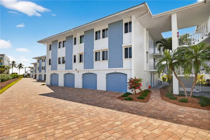 View of apartment building / complex featuring driveway and a garage