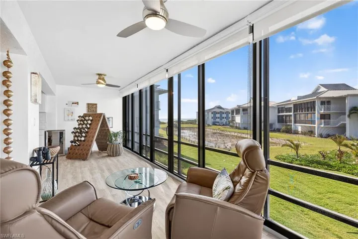 Sunroom / solarium with a wall of windows, wood finished floors, and healthy amount of natural light