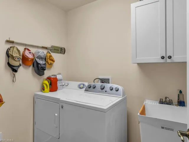 Laundry area featuring cabinets, washer and clothes dryer, and sink