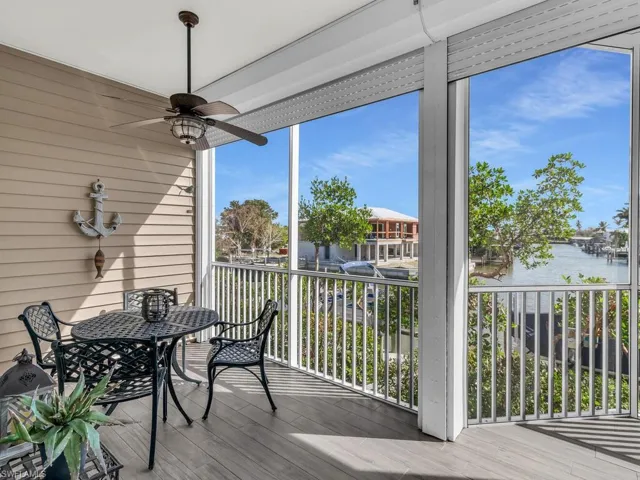 Sunroom with a wealth of natural light, a water view, and ceiling fan