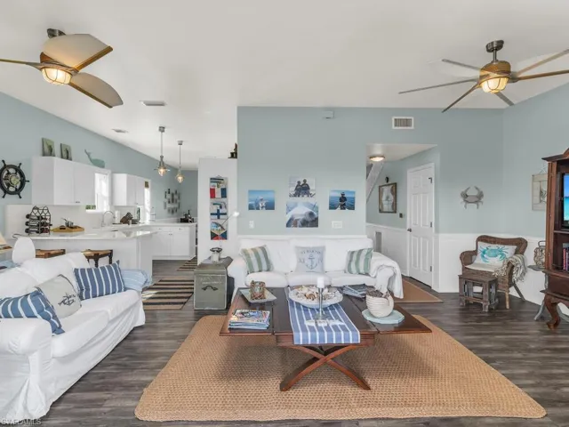 Living room featuring dark wood-type flooring, sink, and ceiling fan