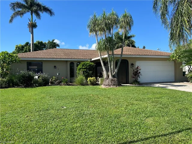 Ranch-style home featuring an attached garage, stucco siding, concrete driveway, and a front lawn