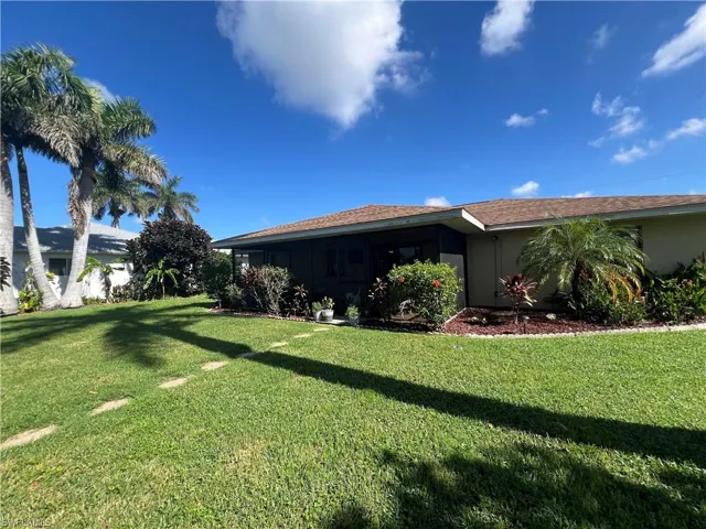 View of home's exterior with a lawn, roof with shingles, and stucco siding