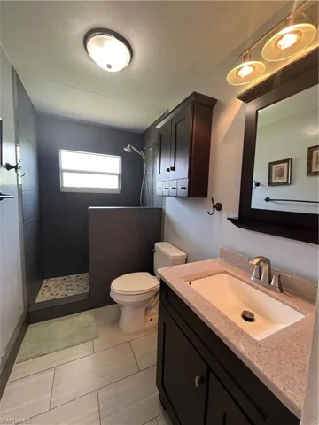 Bathroom with vanity, a walk in shower, and tile patterned flooring