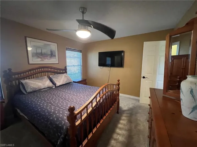 Carpeted bedroom with baseboards and a ceiling fan