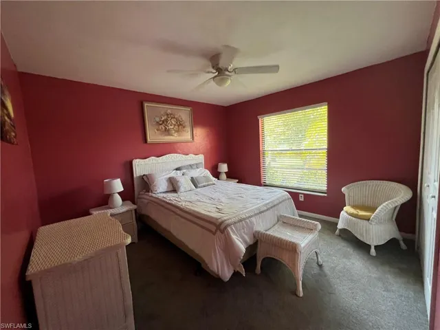Carpeted bedroom featuring baseboards and ceiling fan