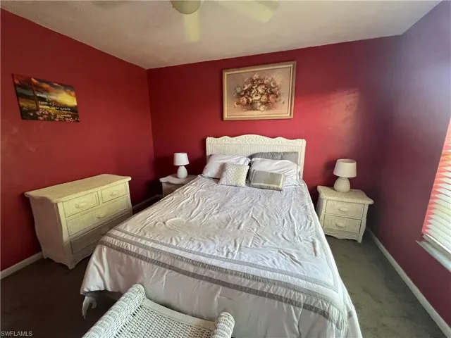 Carpeted bedroom featuring baseboards and ceiling fan