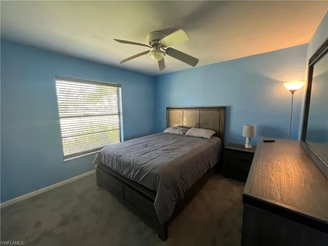 Carpeted bedroom featuring baseboards and a ceiling fan