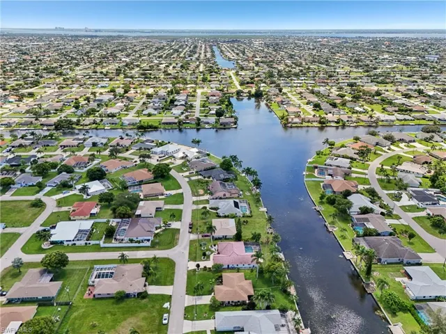 Aerial view of property and surrounding area featuring nearby suburban area