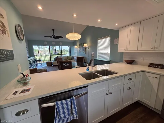 The kitchen features white cabinetry, light-colored countertops, a stainless steel sink with a goose-neck faucet, and a dishwasher