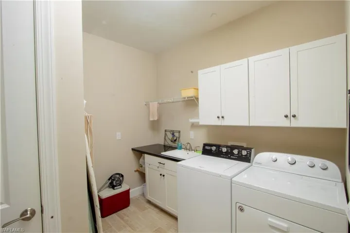 Laundry room with built-in cabinets and utility sink