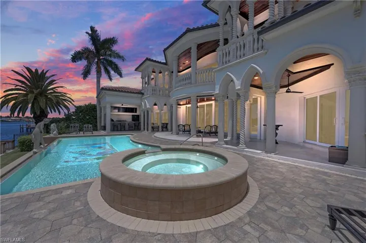 Pool at dusk featuring a patio area, an in ground hot tub, and ceiling fan